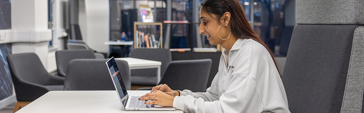 A female Uxbridge student working at her computer